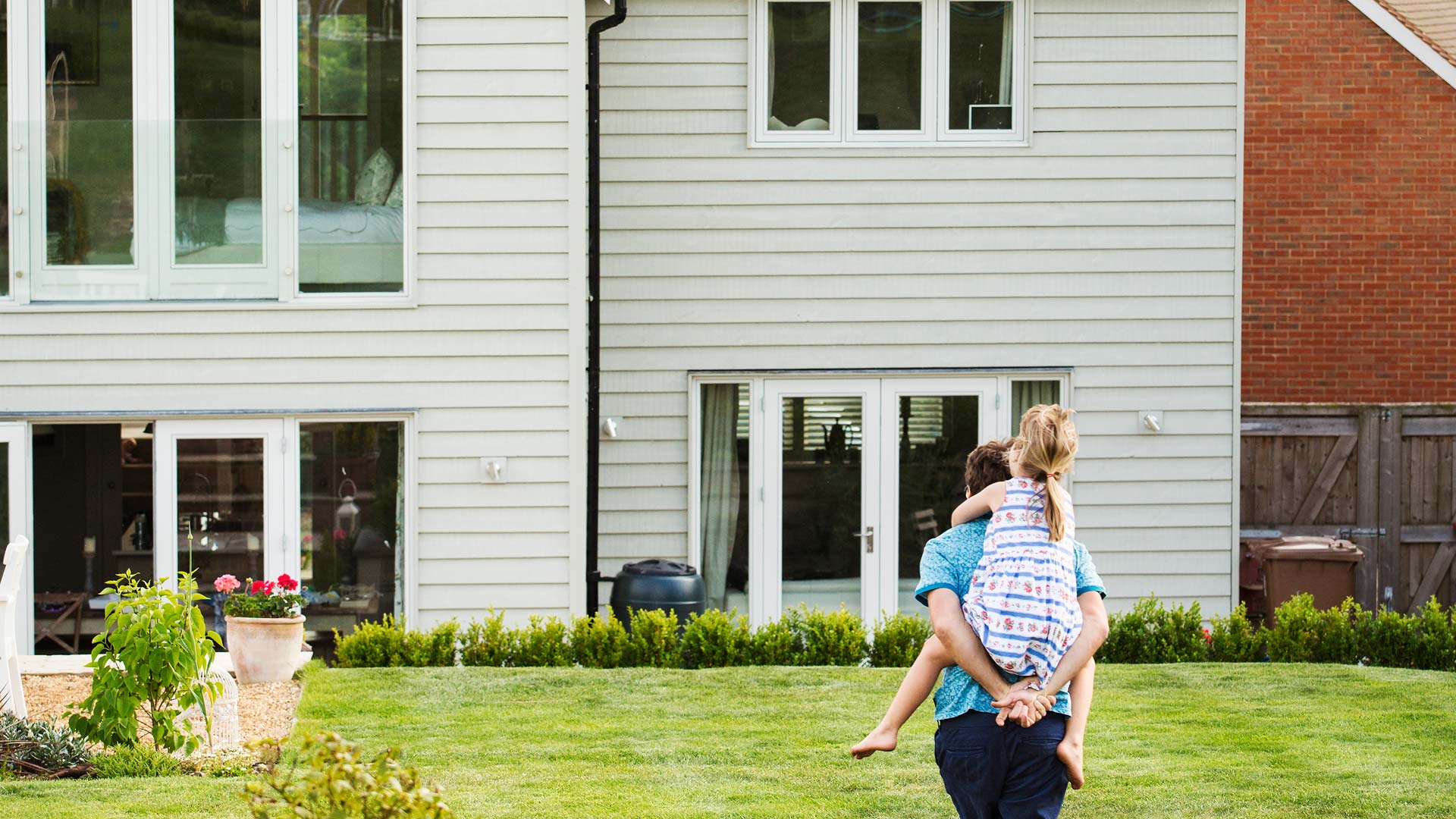 mann_mit_kind_vor_altem_Fertighaus